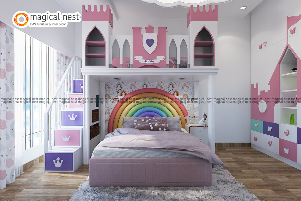 The fairy tale themed kid’s room for the girl  room has a pink and white color scheme with a castle loft. There is rainbow wallpaper and upholstery. 