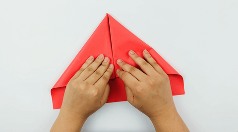 Folding paper edges in to begin making a paper bavarian hat