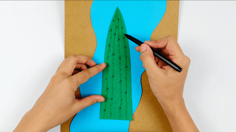 Drawing a paper crocodile onto a green piece of paper for a nile crocodile craft