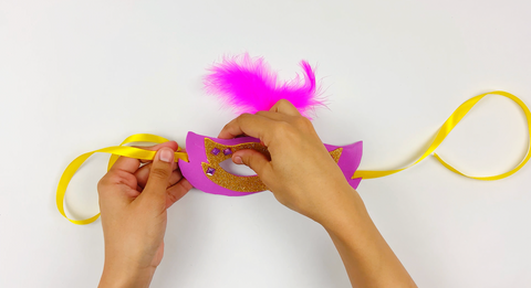 Gluing ribbon to the edge of Italy Carnival mask