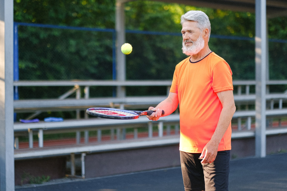 Elderly man playing tennis 