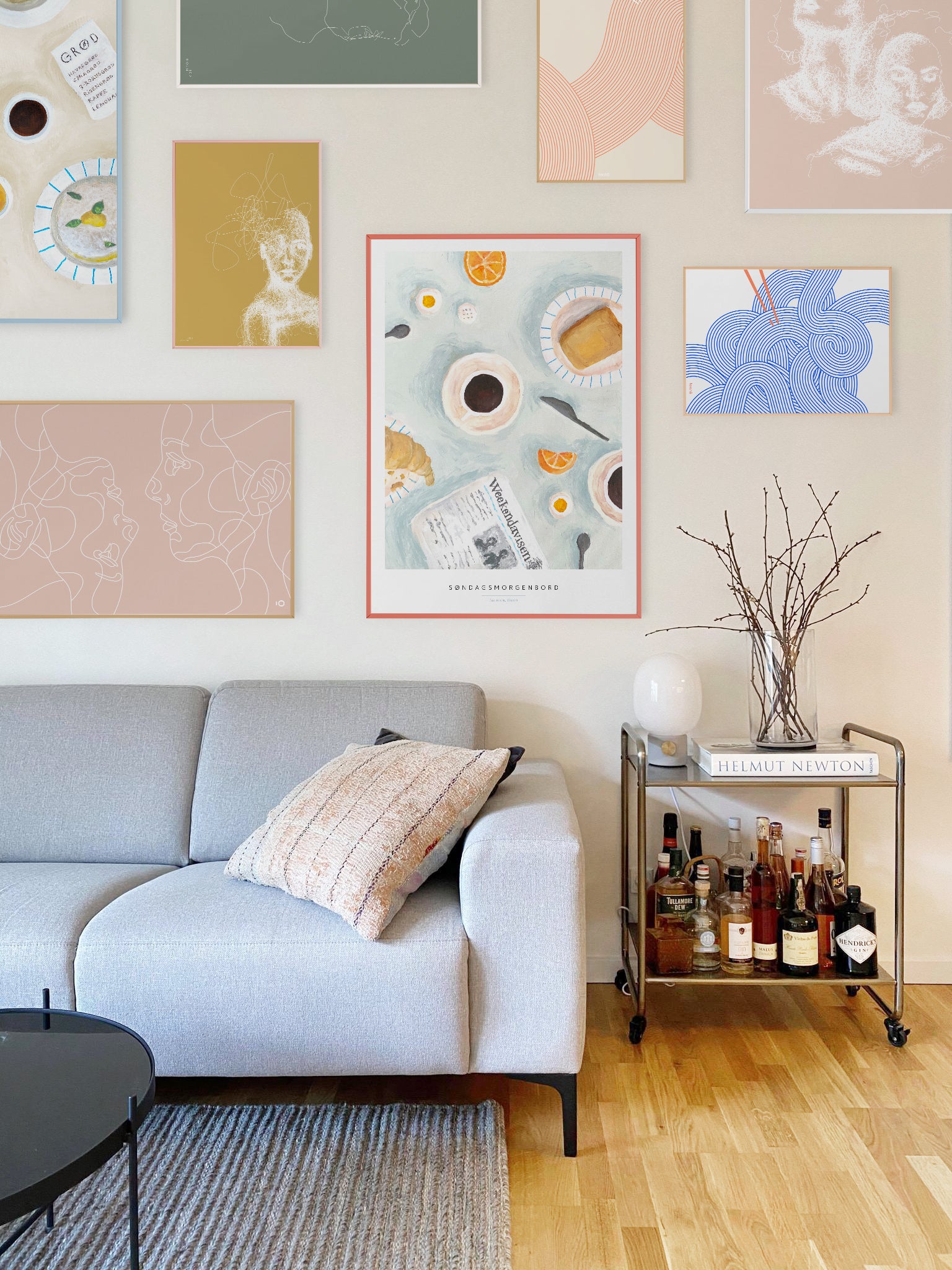 billedvæg med taisho-plakater på hvid væg med grå sofa