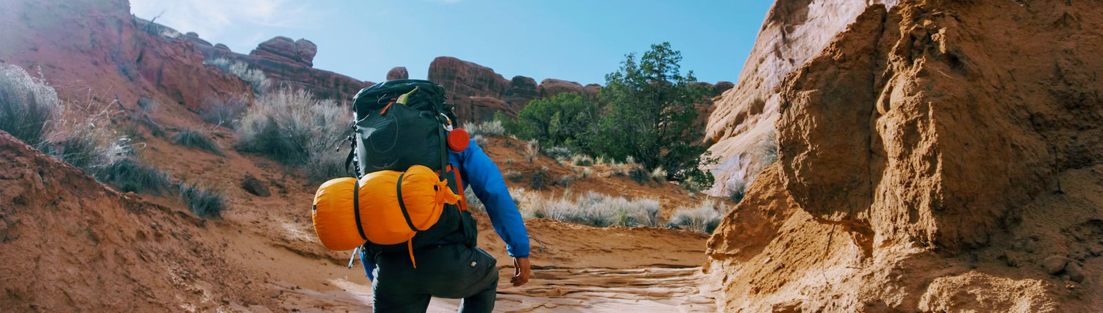 Hiker climbing up rocky trail in a desert