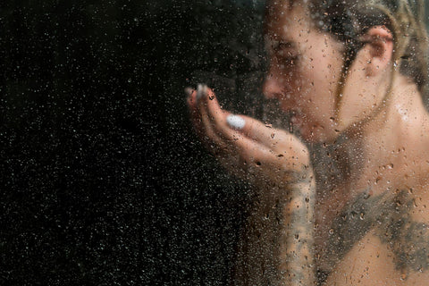 Woman in the shower on dark background