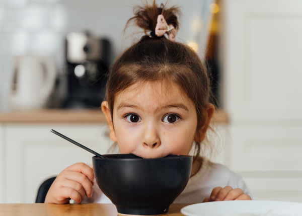 Little female toddler making a face while not eating her food