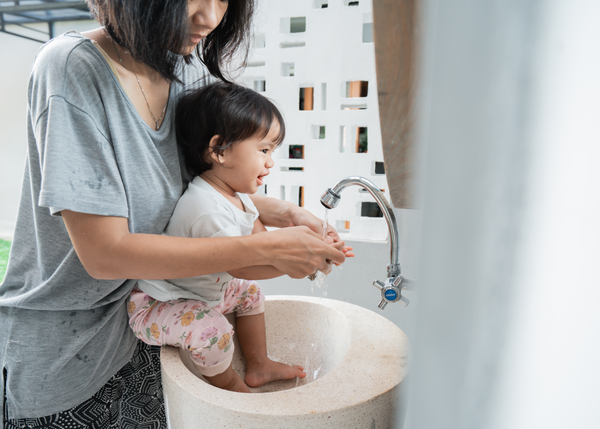 Baby in a basin with mum washing their hands