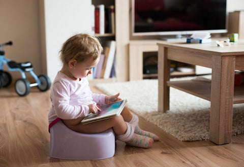 girl on potty reading a book