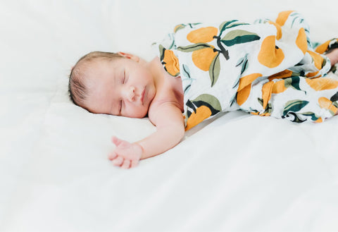 baby sleeping with a fruit patterned swaddle