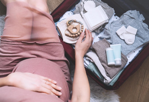 pregnant woman packing suitcase for hospital