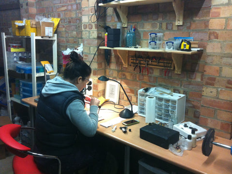 Katie McCann in the Mintique of Cambridge workshop working on a customers coin ring