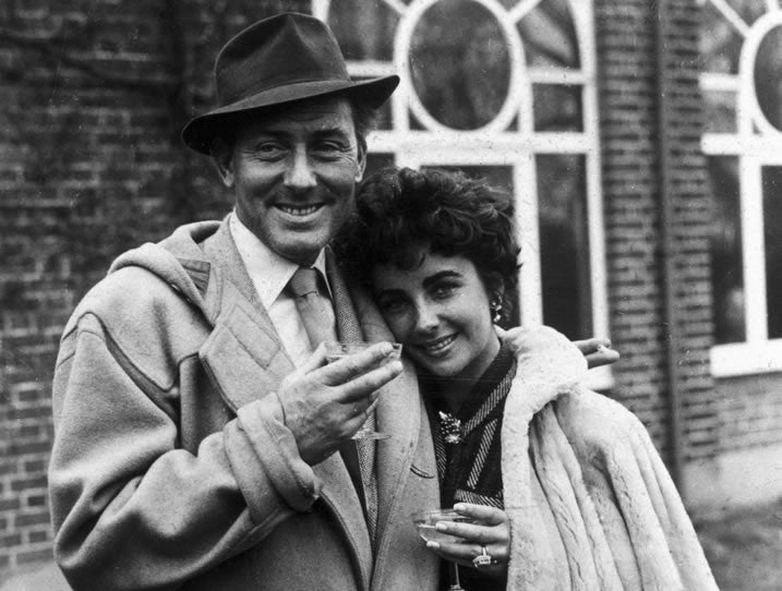 Actor Michael Wilding wears the duffle coat stood with film star wife, Elizabeth Taylor.