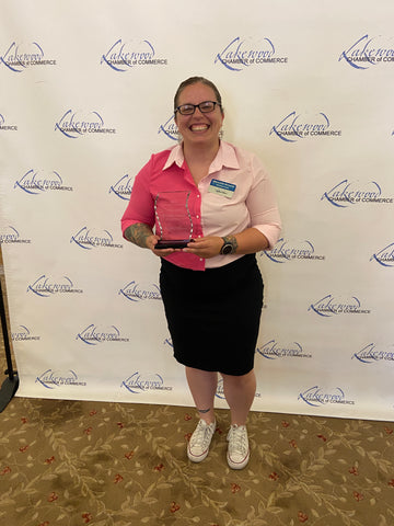 Meredith Russell holding her Entrepreneur of the Year award from the Lakewood Chamber of Commerce, 2023.
