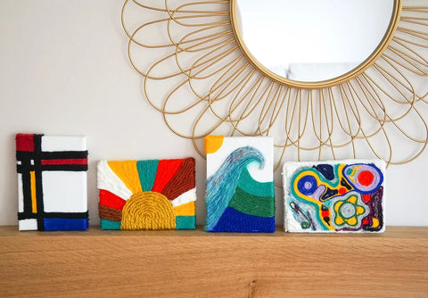 Four yarn paintings on mantle with round mirror