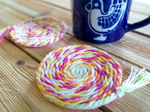 Two yarn coasters with blue cup