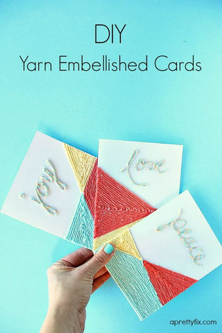 yarn on cards says joy, love, and peace