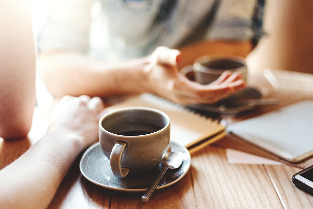 Two women talking while drinking coffee