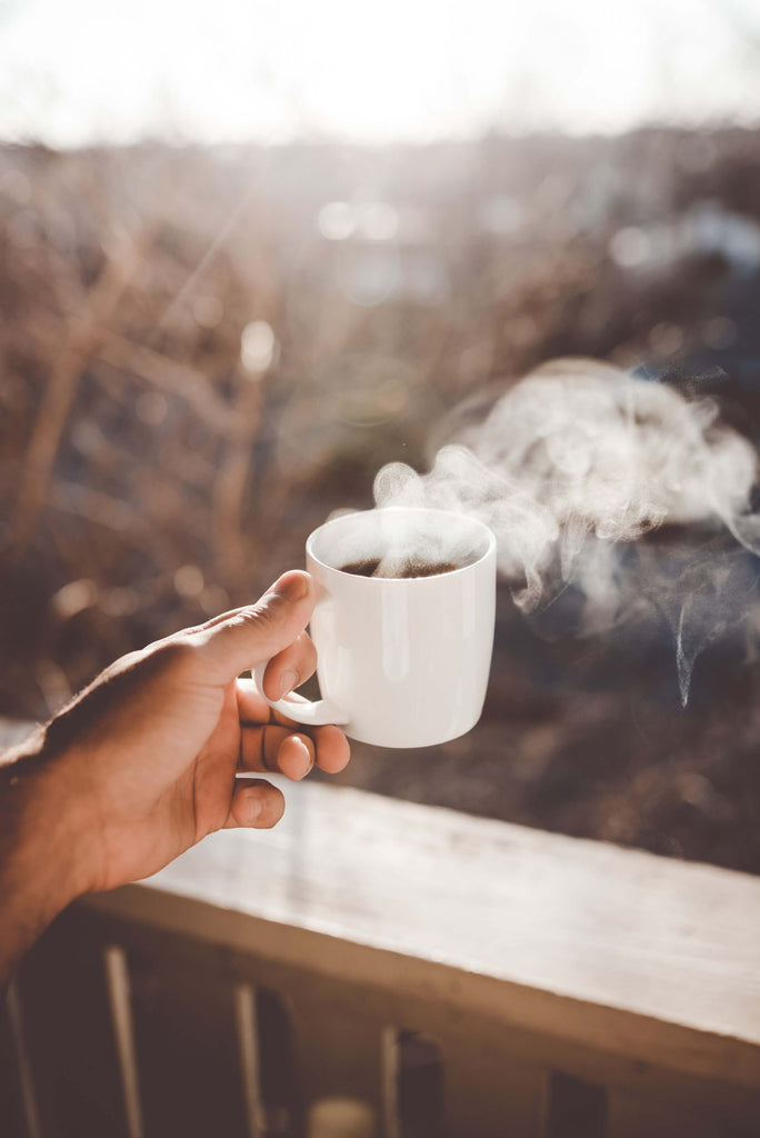 a person pours milk into coffee