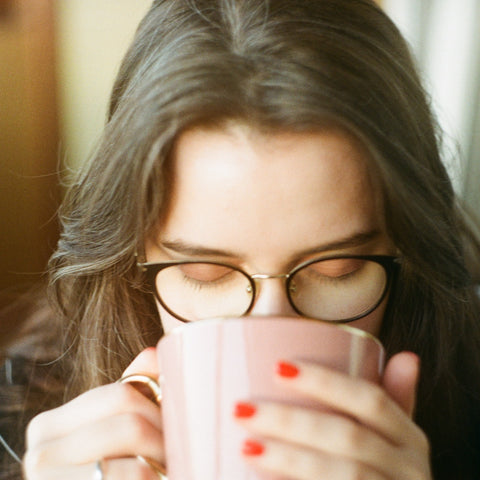woman sipping out of mug
