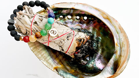 cleansing crystals by smudging with sage. crystal bracelet sitting on top of sage