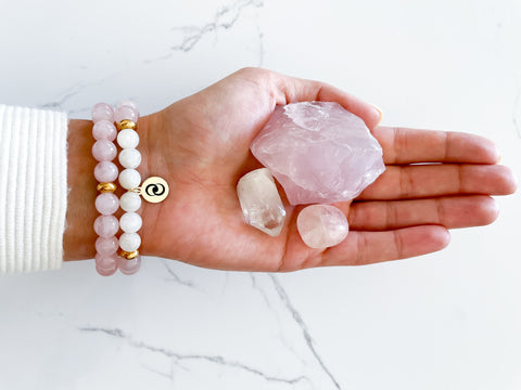 Hand wearing an everlur love and relationship bracelet with rose quartz and moonstone to manifest selflove