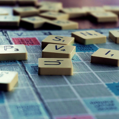 Scrabble board with letter tiles scattered