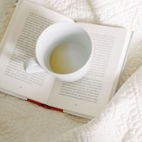 Reading in bed with a cup of coffee