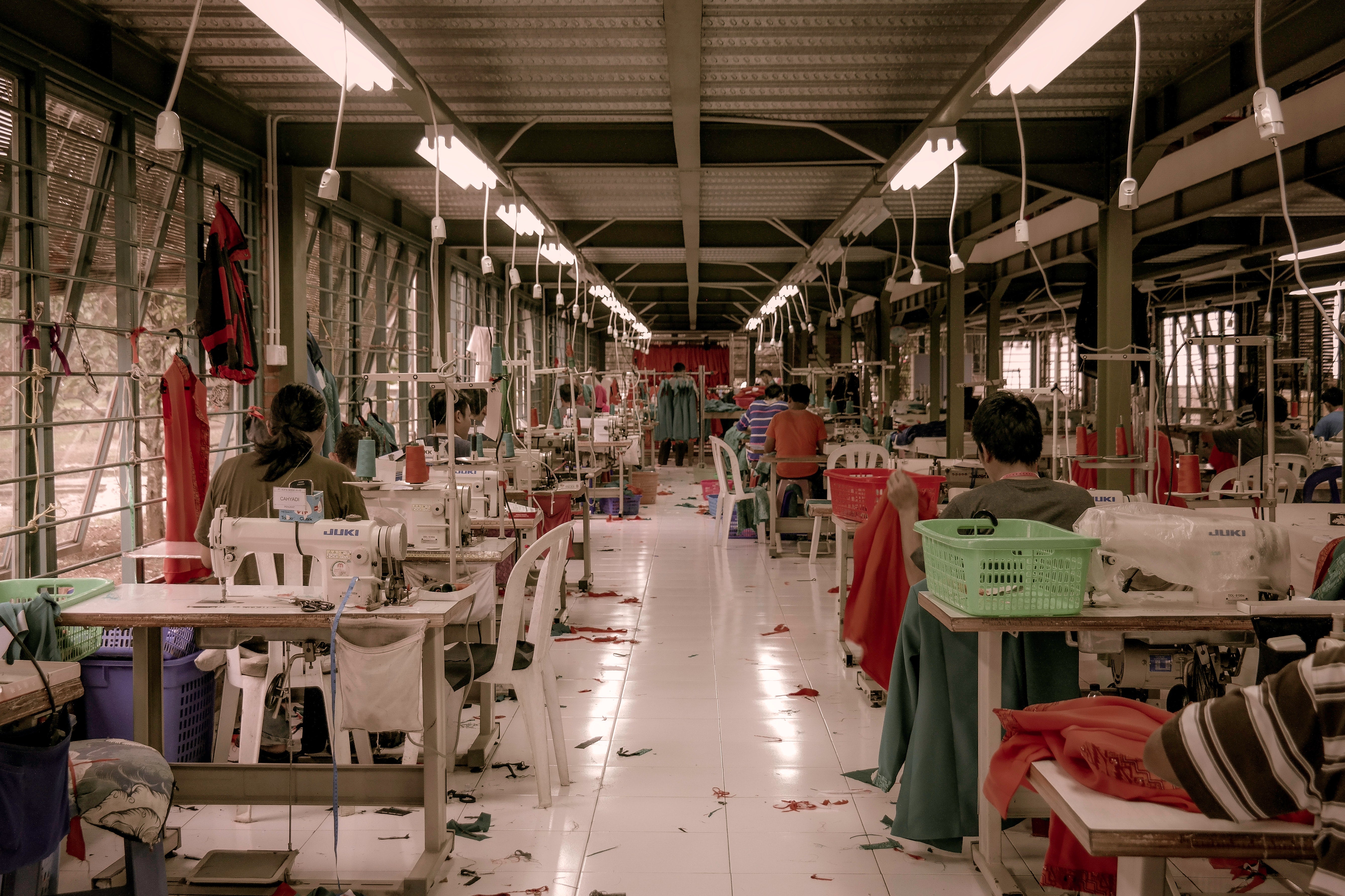 Intérieur d'une usine de l'industrie textile, avec des tissus mal rangés. Eclairé aux néons, sans fenêtres et sans humains ou coututières. 