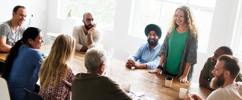 A group of professionals convening around a board room table to discuss sustainable career paths.