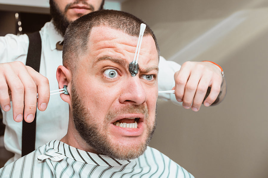 Surprised man getting his face and ears waxed