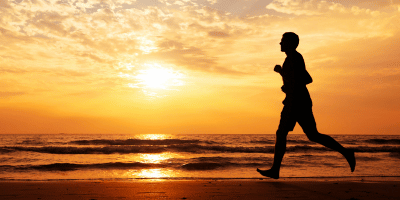 Man running on the beach at sunset