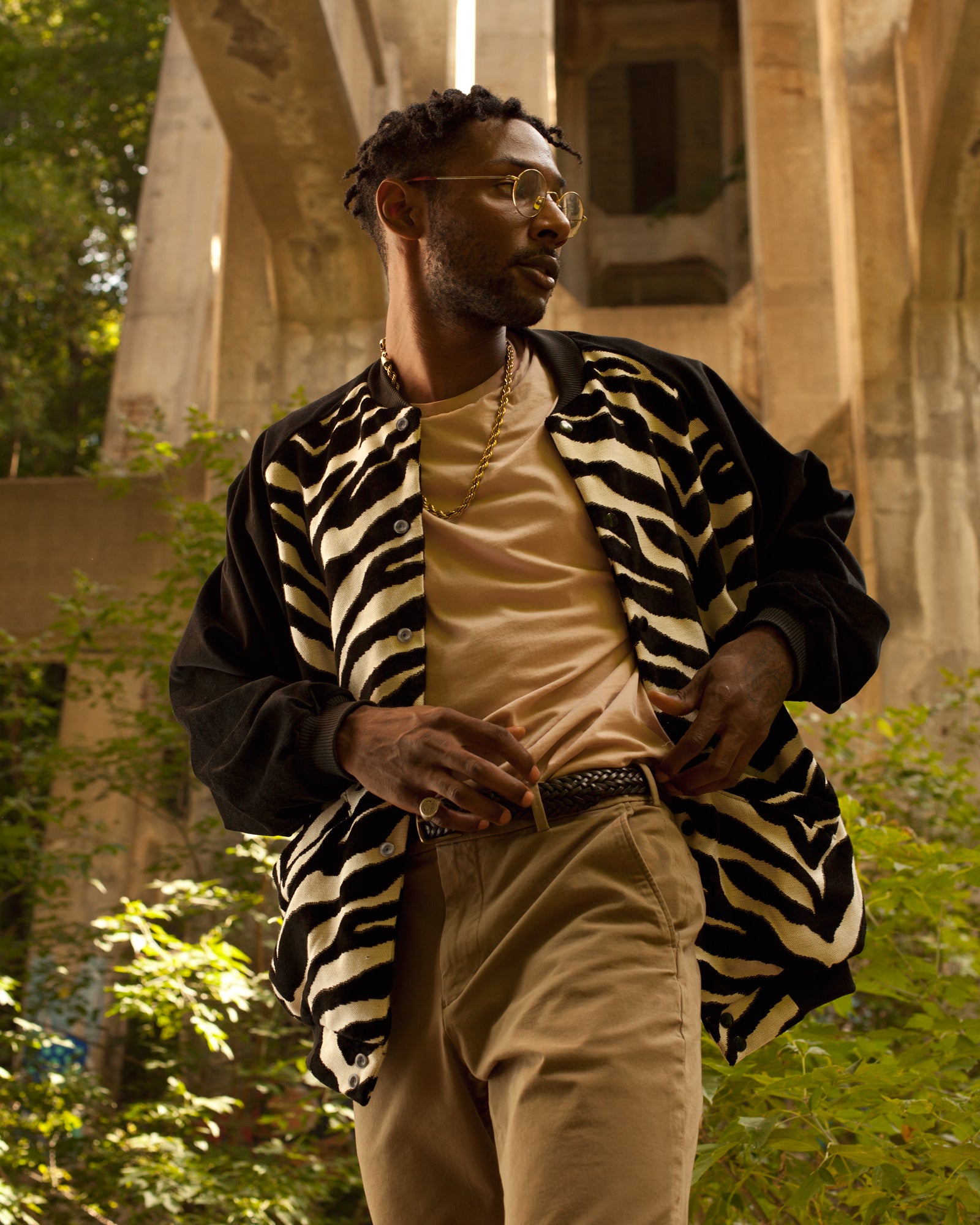 photo of model standing underneath bridge wearing the House of Glass Don't Wanna Be Spotted Bomber Jacket