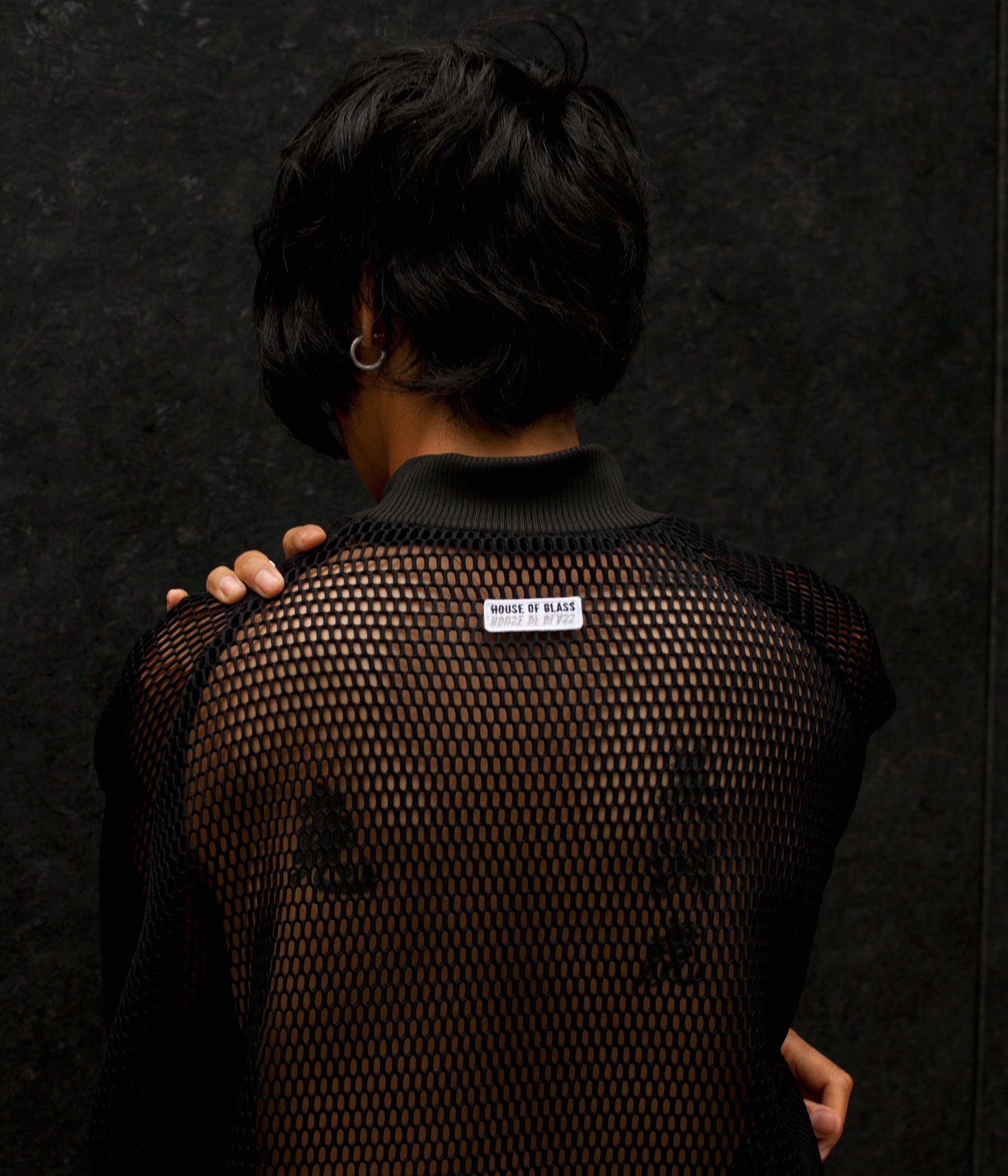 picture of model wearing House of Glass Hot Mesh Tracksuit with their back to the camera showing the House of Glass logo patch