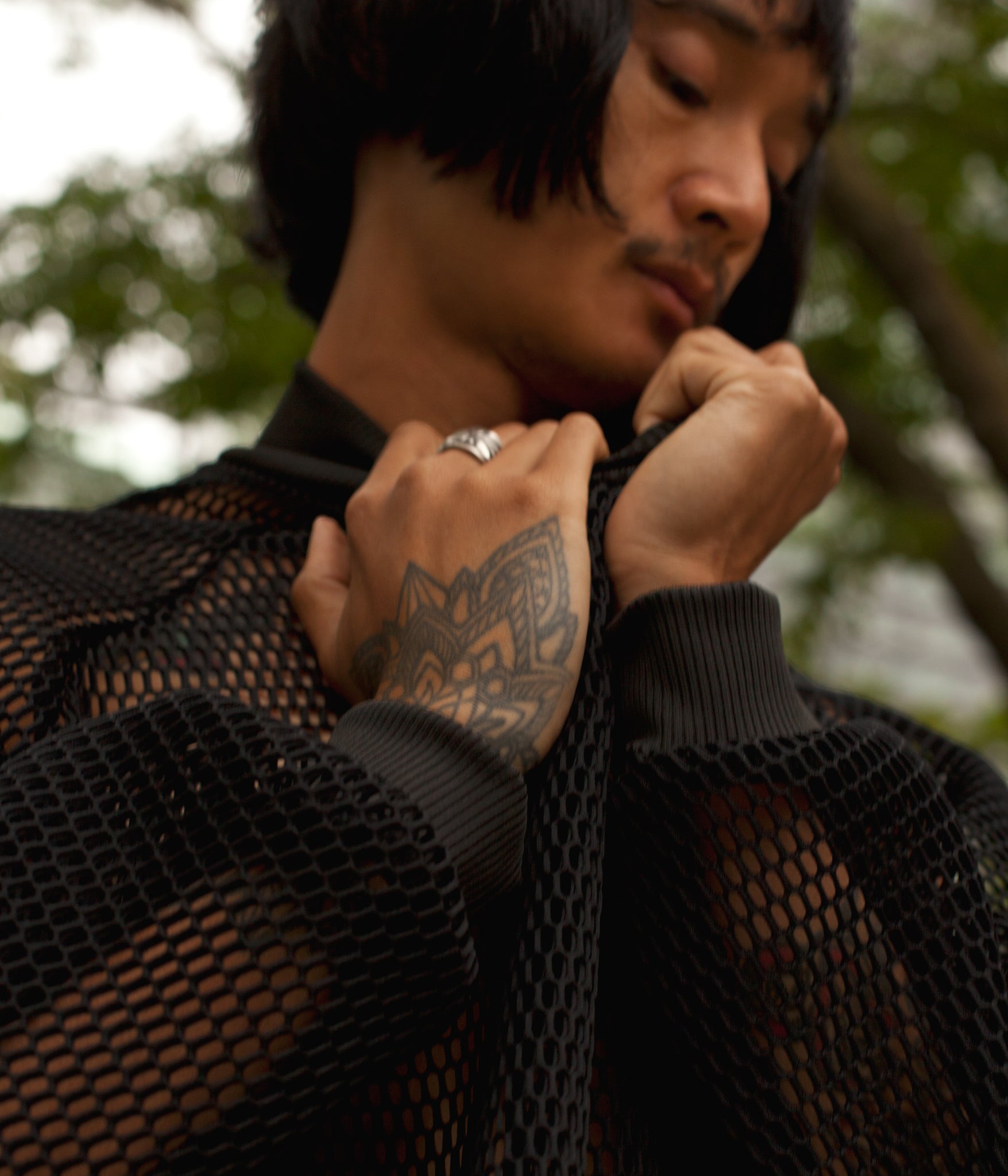 close up image on model wearing the House of Glass Hot Mesh Tracksuit while wrapping their hands in the material