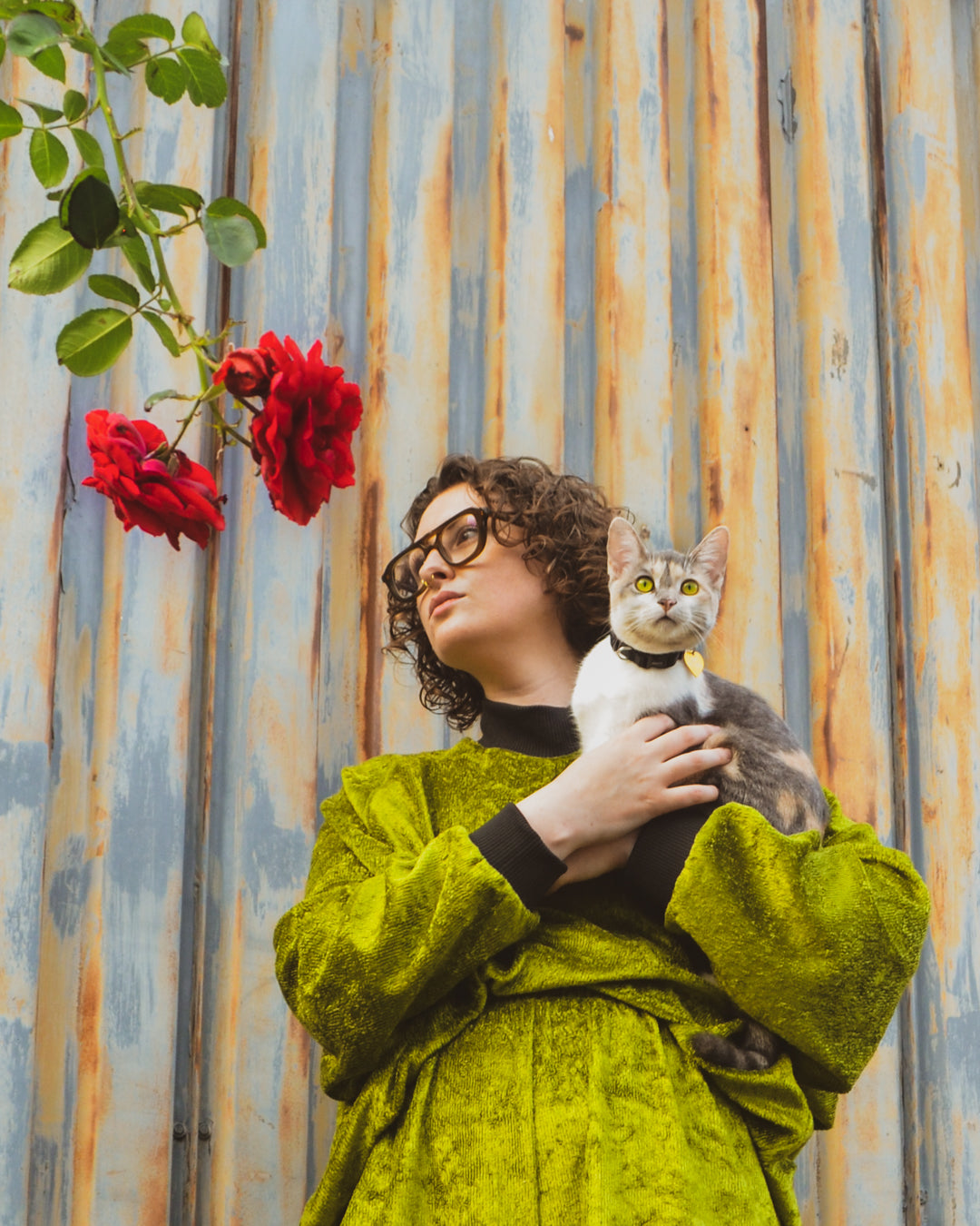 non binary model cuddles a small cat while wearing the House of Glass Oscar Halfsuit