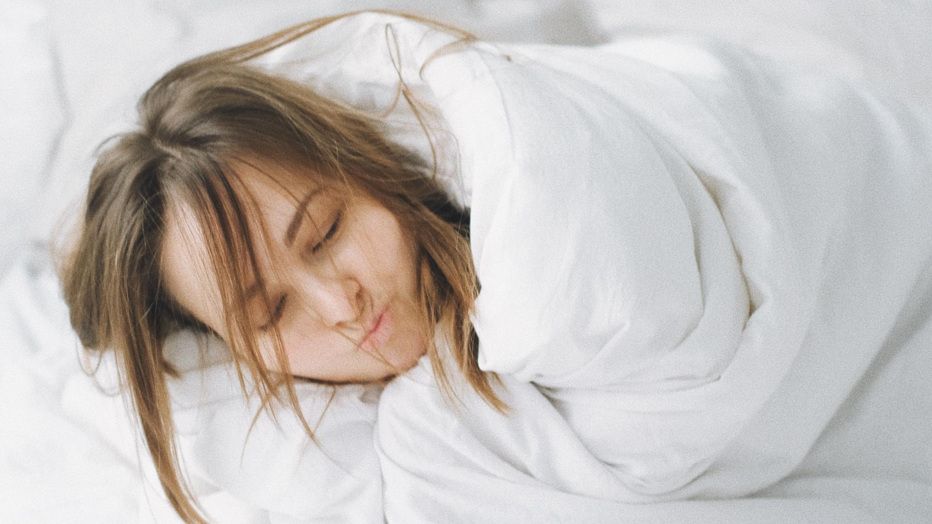 Woman covered in sheets getting beauty sleep