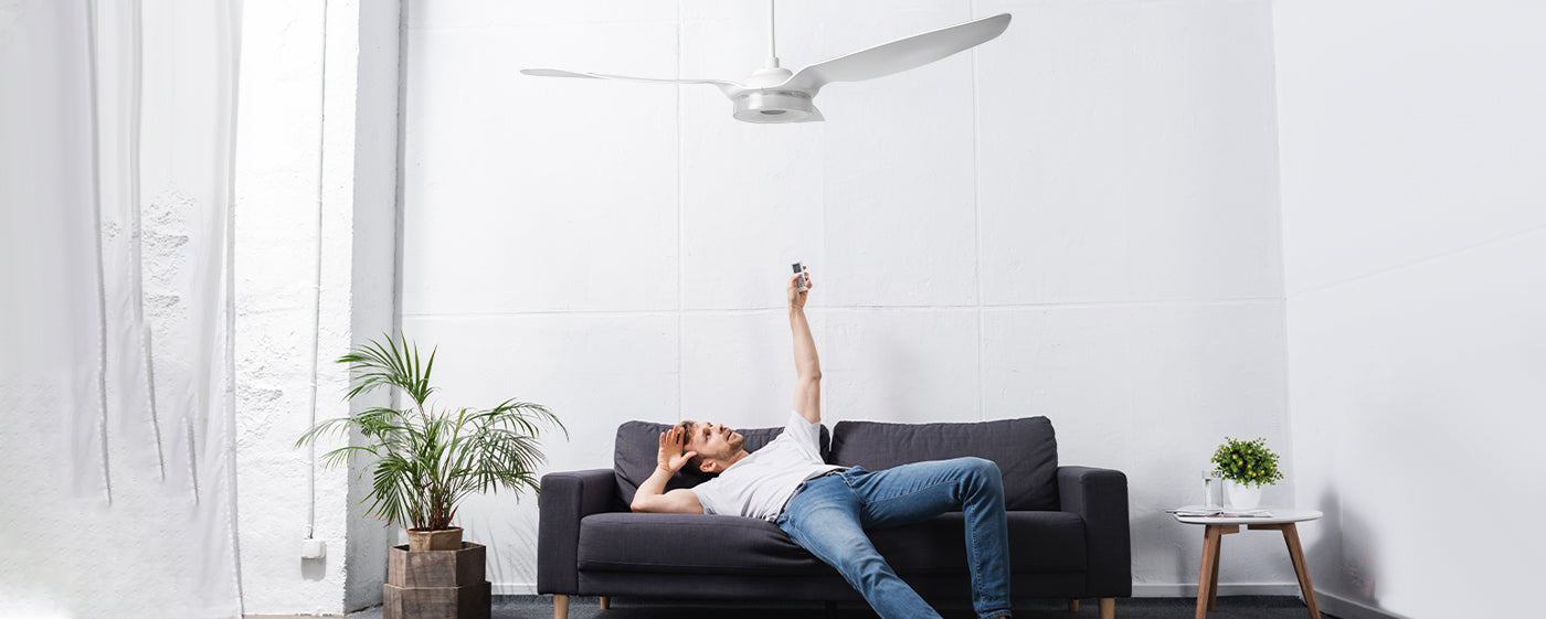 An exhausted and sweaty man came home and stretched out on the couch and turned on the ceiling fan