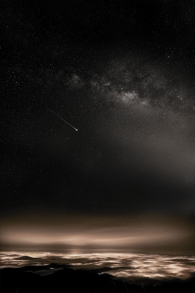 Meteorite falling through the sky above the clouds