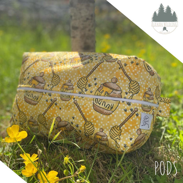 A pod with a honey themed print sitting on the grass. 