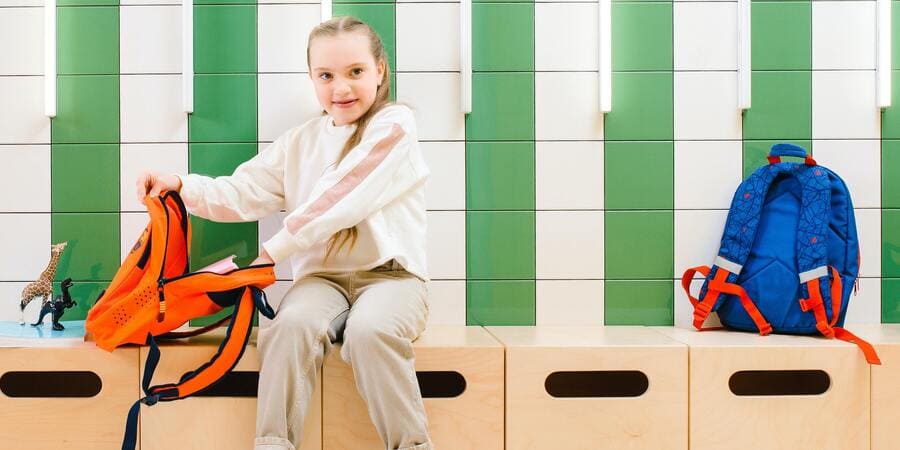 Young Girl Opening Orange Backpack | Pakapalooza