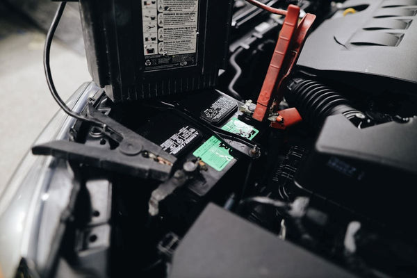 Technician adding water to forklift battery cells