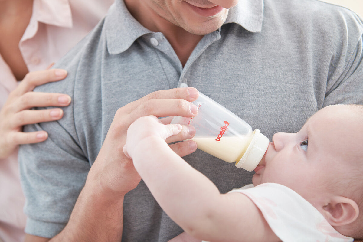 dad feeding baby with bottle