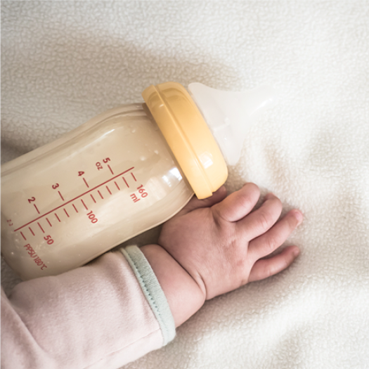 baby hand and baby bottle