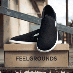 Kamera filmt Model mit weißen Feelgrounds Schuhen & Droptop Mesh Black & White auf Feelgrounds Schuhkarton