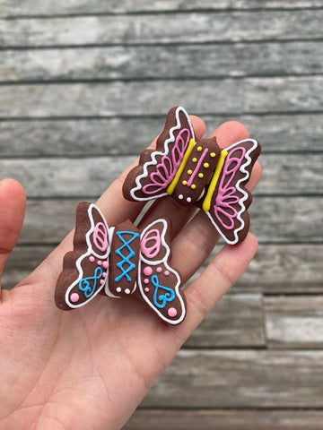 Two Butterfly Cookies resting on a hand.