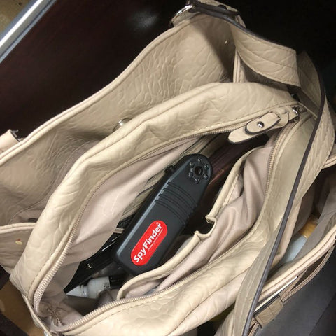 portable spyfinder camera detector inside woman's beige purse