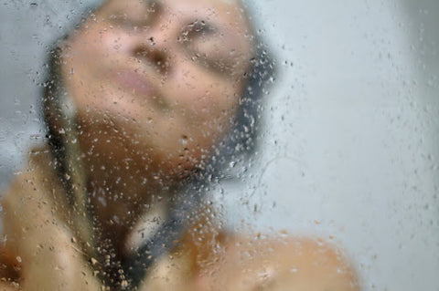 Person's face behind steamed glass shower wall, for Ivy Leaf Skincare blog