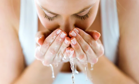 Woman splashing face with water, for Ivy Leaf Skincare blog
