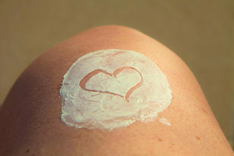 Heart drawn into swatch of moisturizer on person's knee, for Ivy Leaf Skincare blog