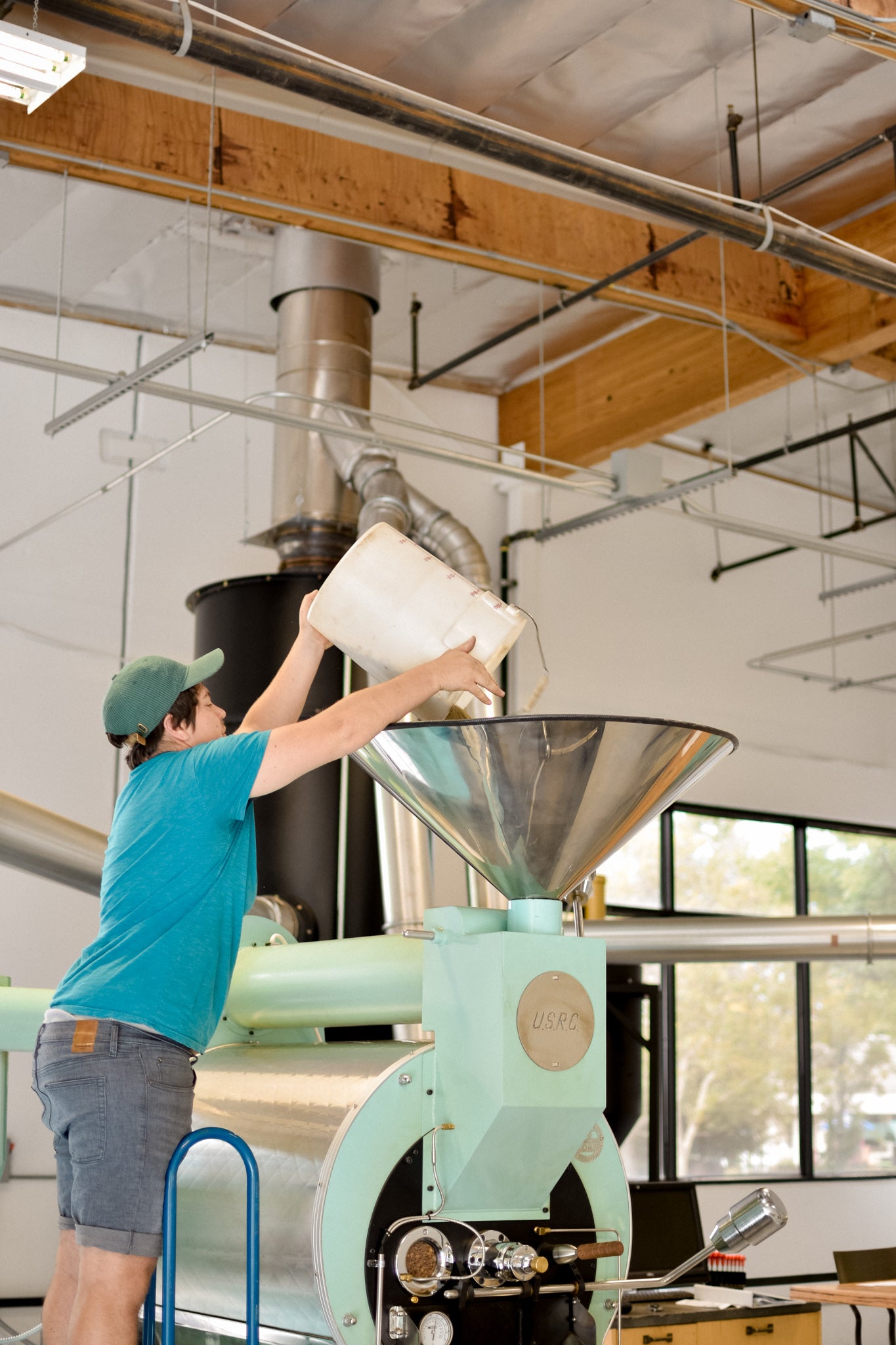 Green coffee going into coffee roaster