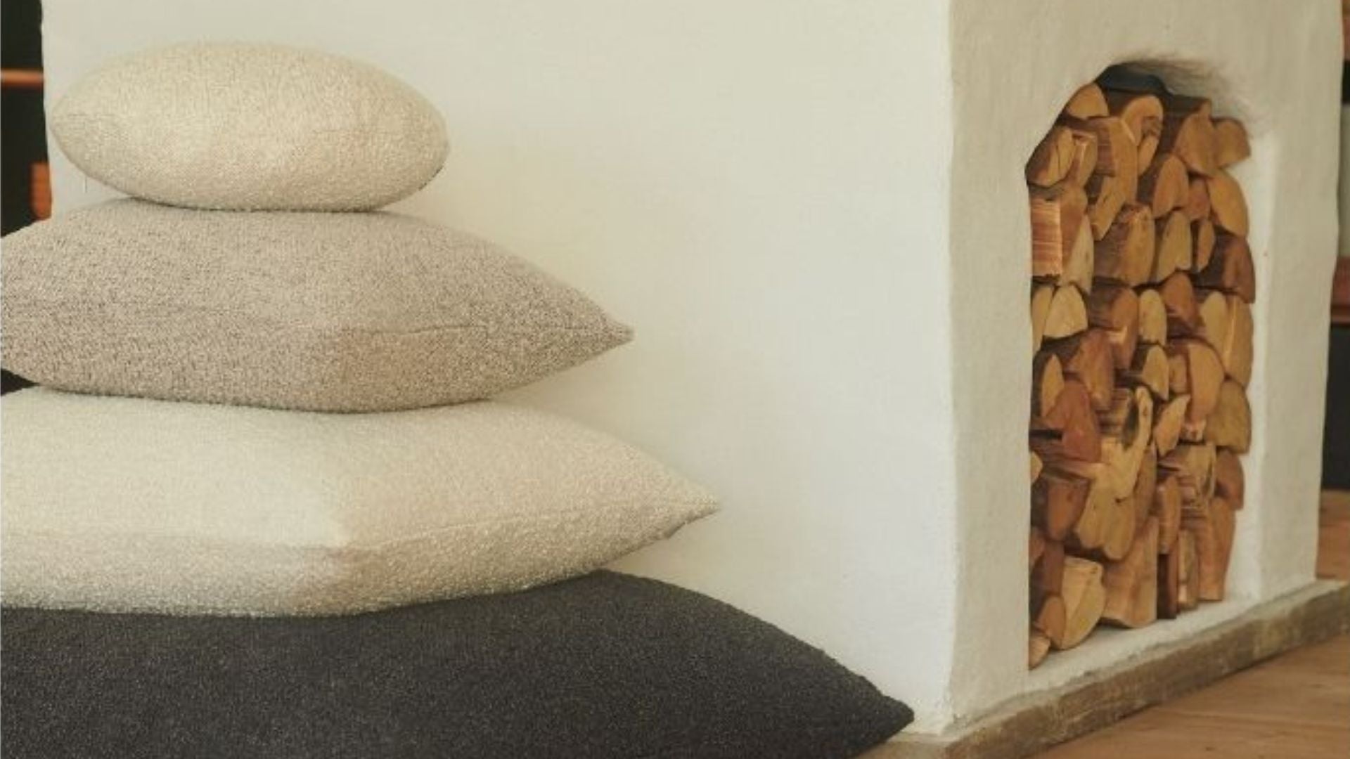 Hommey cushions stacked up next to a wood fireplace